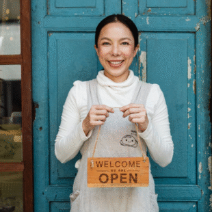 Small business owner holding an open sign, symbolizing brand authenticity and a welcoming local presence.
