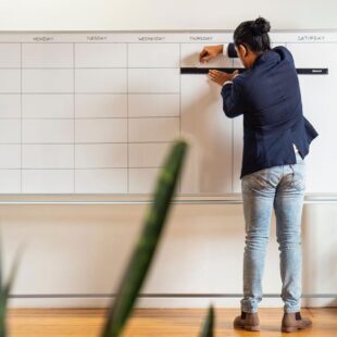 Team member organizing a calendar whiteboard, symbolizing strategic planning for a growing Chattanooga Business.