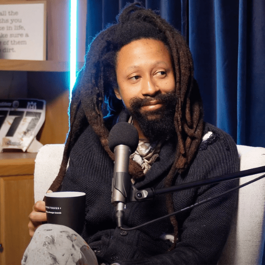 Genesys the Grey Kid as a guest on the Spectruss Speakeasy podcast, holding a Spectruss mug.