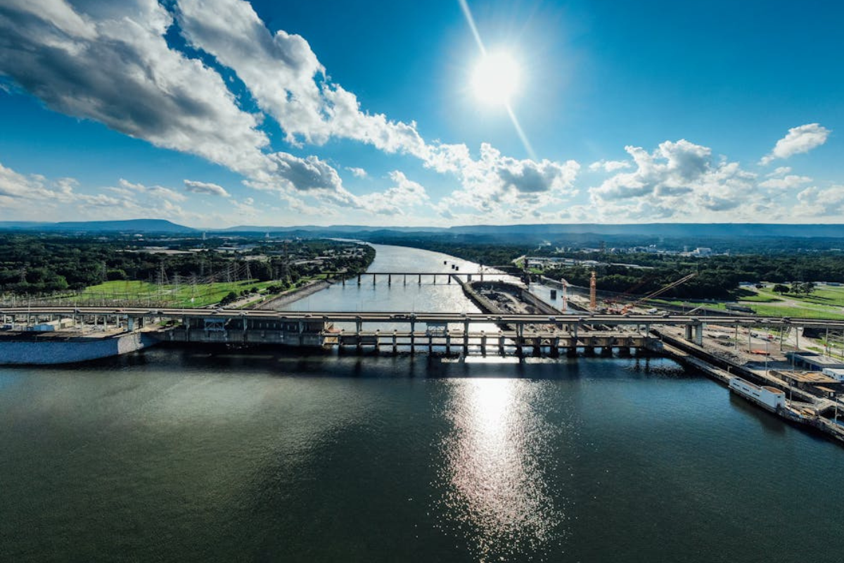 Sunlit view of the Tennessee River and industrial bridge in Chattanooga, capturing the essence of the Chattanooga landscape and local language