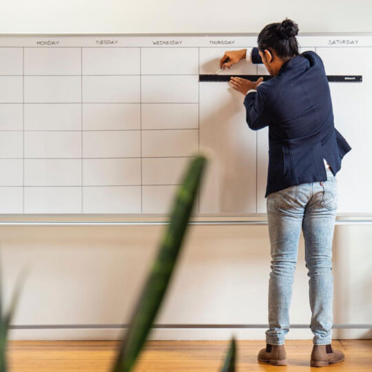 Team member organizing a calendar whiteboard, symbolizing strategic planning for a growing Chattanooga Business.