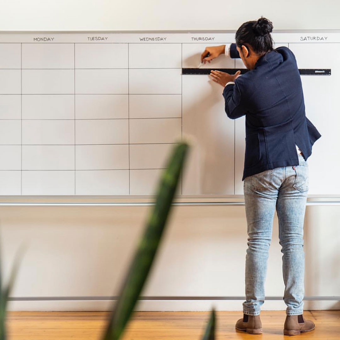 Team member organizing a calendar whiteboard, symbolizing strategic planning for a growing Chattanooga Business.