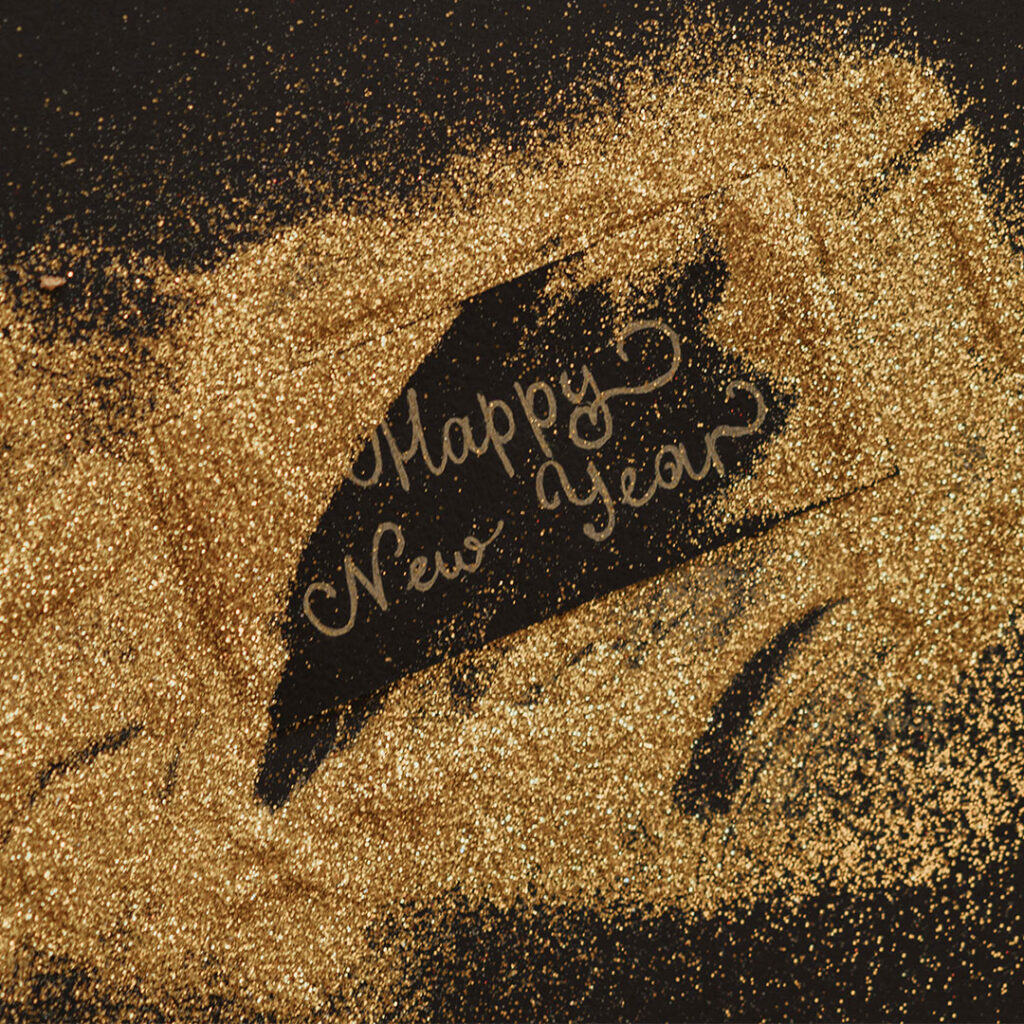 Gold glitter spelling out "Happy New Year," symbolizing new opportunities for a Chattanooga Business.