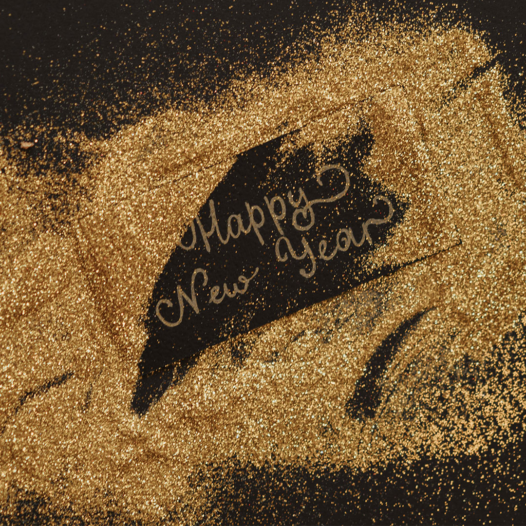 Gold glitter spelling out "Happy New Year," symbolizing new opportunities for a Chattanooga Business.