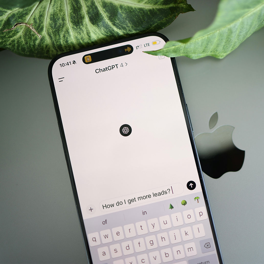 Smartphone displaying an AI tool (ChatGPT) with the question, "How do I get more leads?" highlighting AI in Marketing.