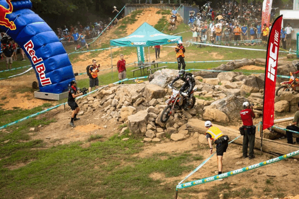 Sam on his dirt bike with the number 424 jumps a large wooden log obstacle during the Spectruss Racing hard enduro event.