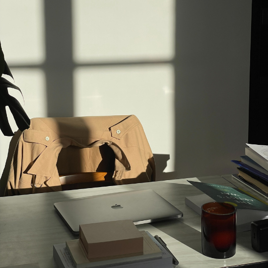 A desk with a laptop, notebooks, and a coffee cup, representing a space for strategic marketing planning.