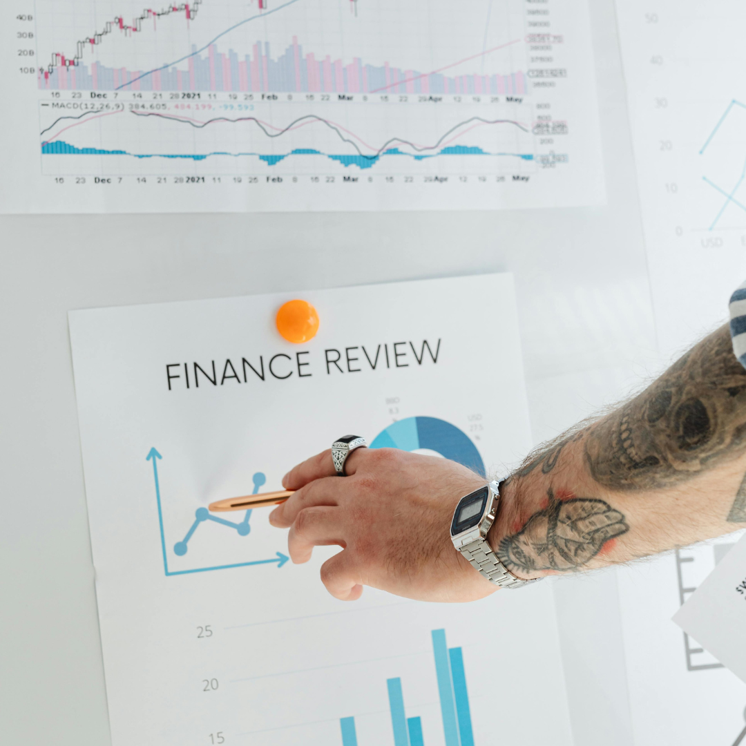Person pointing to finance review growth chart with marketing performance data