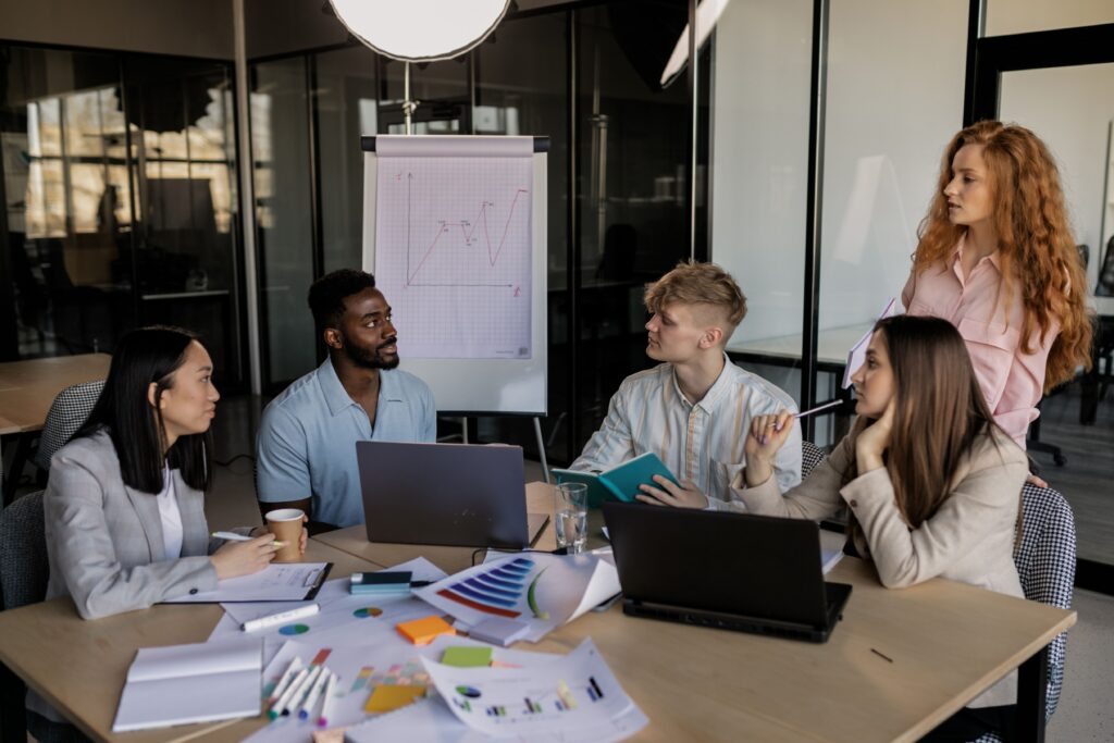 Marketing team meeting with charts and a flip chart as a company weighs a fractional CMO vs. full-time CMO
