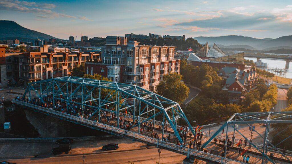 Aerial view of downtown Chattanooga, TN, at sunset with a steel bridge, the Tennessee River, and the Tennessee Aquarium