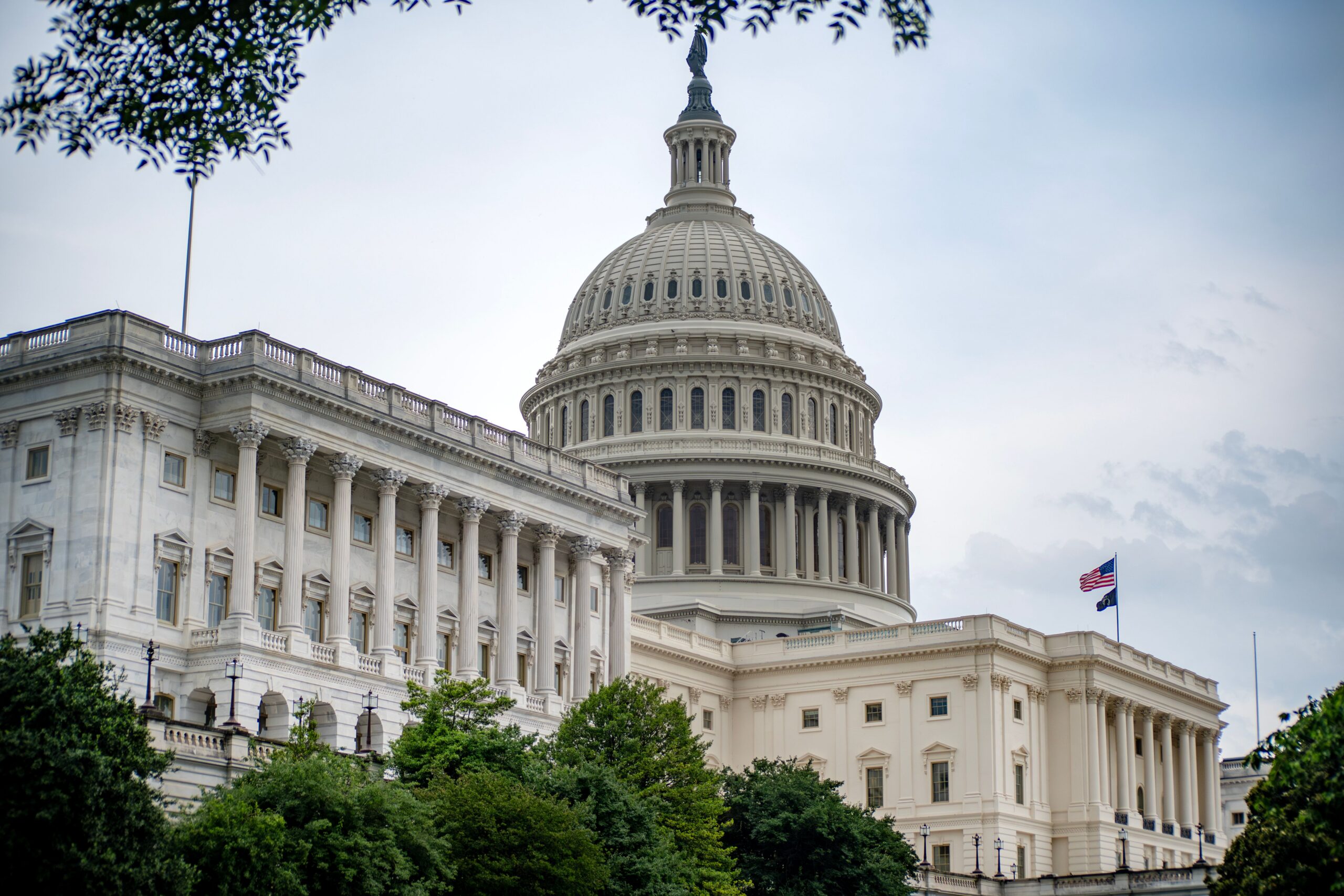 U.S. Capitol dome and building exterior in Washington, D.C. under a cloudy sky